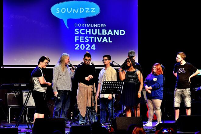 Das Bild zeigt viele junge Menschen auf der Bühne des Dortmunder Jazzclubs domicil.