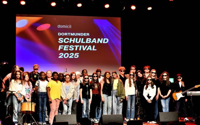 Das Bild zeigt viele junge Menschen auf der Bühne des Dortmunder Jazzclubs domicil.