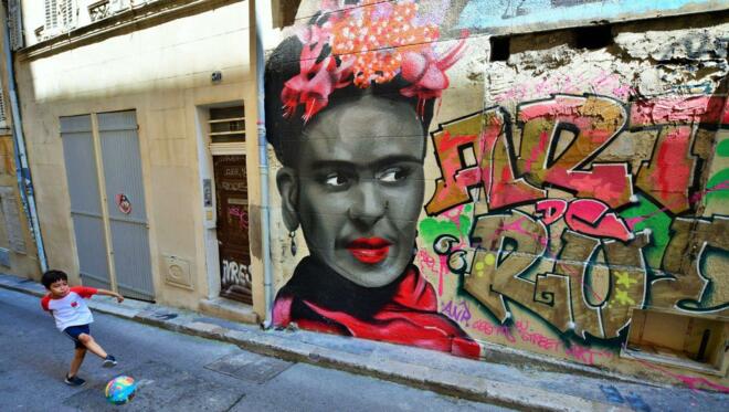Street Art in Marseille: Portät von Frieda Kahlo mit spielendem Jungen.