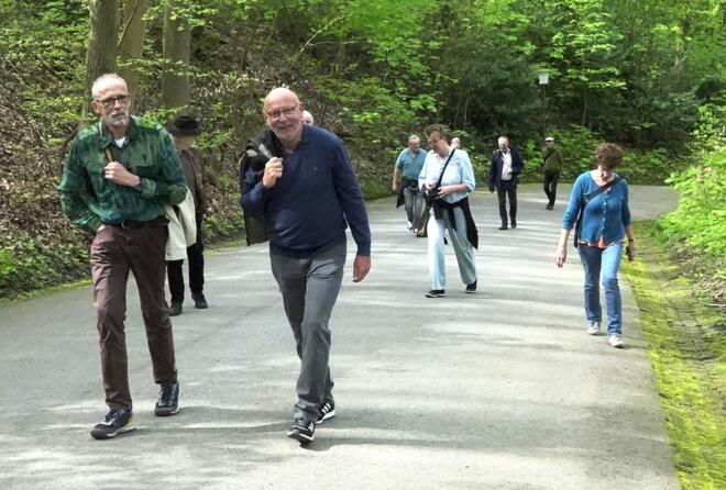 Menschen steigen eine steile Straße aufwärts.